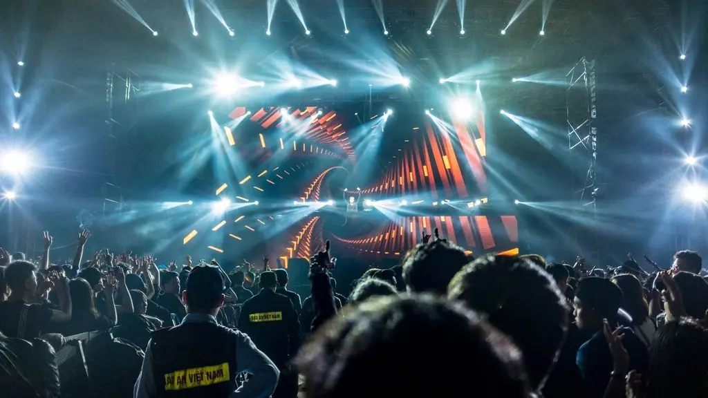 Stage lights in blue and orange over a crowd