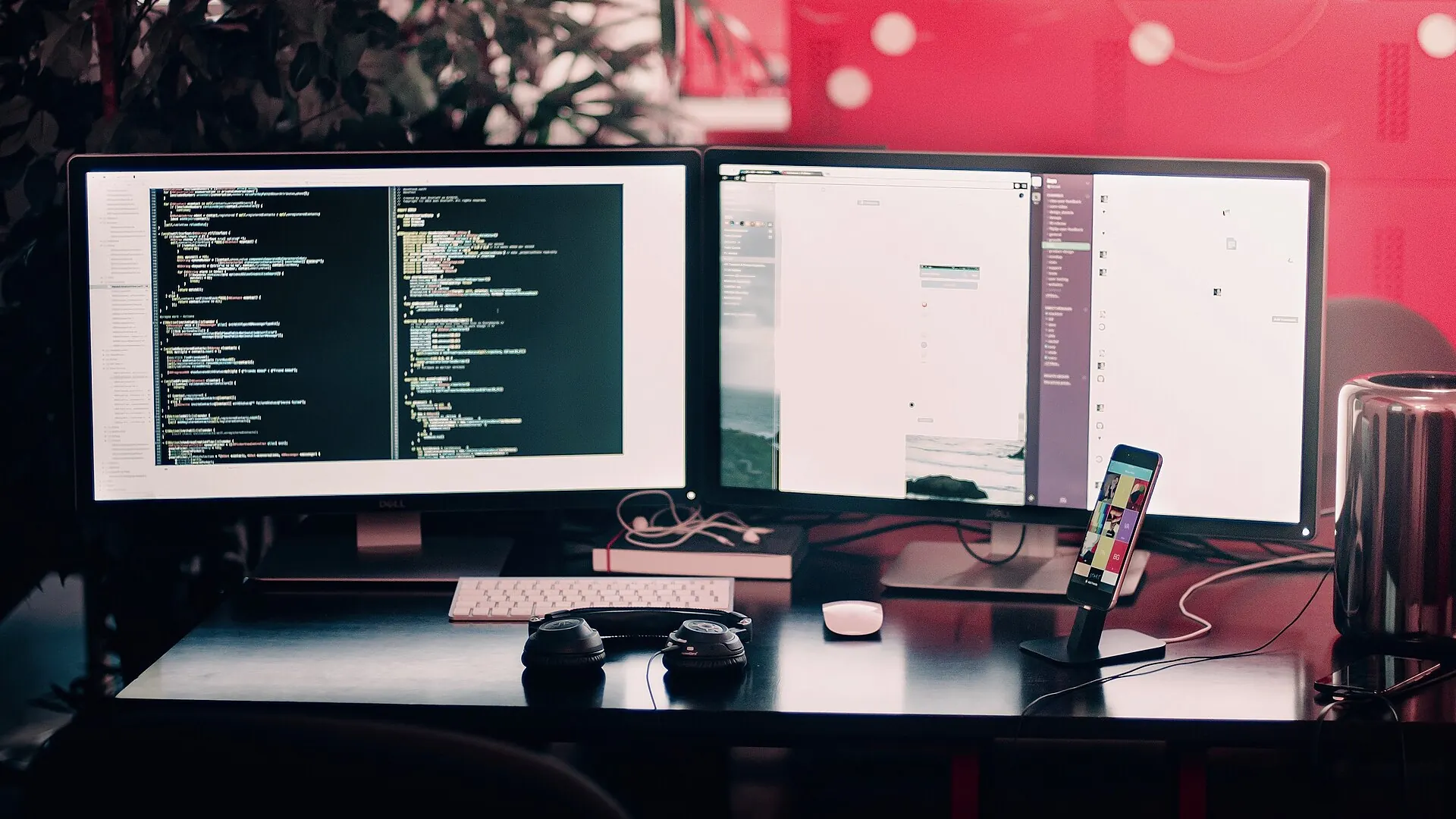 Two screens with code on a dark desk
