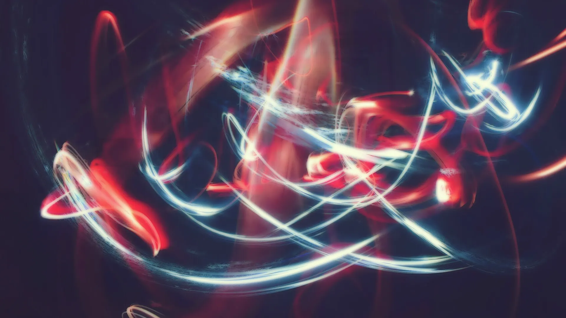 Red and blue streaks of light over water at night